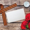 2020Holidays___May_9_Red_carnations__St._George_ribbon_and_candles_on_the_table__template_for_greeting_card_on_May_9_Victory_Day_141037_.jpg