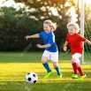 103987606-kids-play-football-on-outdoor-field-children-score-a-goal-at-soccer-game-girl-and-boy-kicking-ball-r.jpg